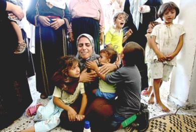 شقيقة الشهيد اسماعيل تحتضن اطفالها وتبكي أثناء تشييع جثمانه