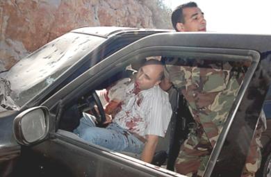 رجل الشرطة ومسعفون يخرجون المصابين من رجال الأمن الداخلي اللبناني في انفجار قنبلة على جانب الطريق قرب مدينة صيدا الجنوبية أمس