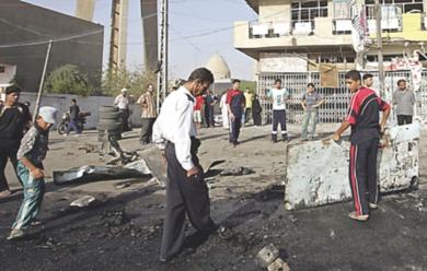عراقيون يقومون بتنظيف مكان وقوع الحادث