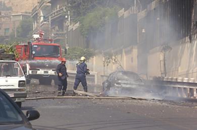 رجال الاطفاء يقومون باخماد الحريق في احدى السيارات المتضررة