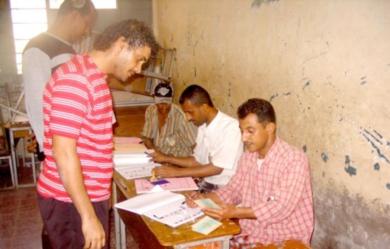 أعضاء اللجنة يتفحصون بطائق المقترعين في أحد مراكز الاقتراع بمديرية صيرة