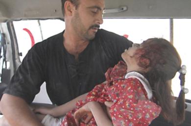 عراقي يحمل ابنته التي اصيبت في الانفجار