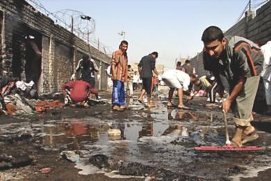عراقيون يمسحون وينظفون آثار الدماء الذي خلفه الانفجار