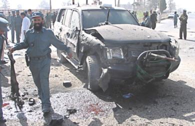 احدى السيارات المتضررة ..وجندي افغاني يقوم بابعاد المواطنين 