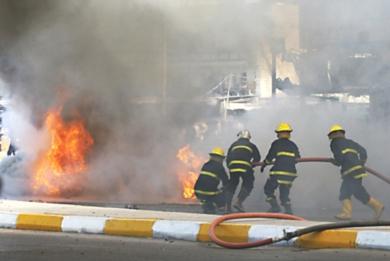 عمال الاطفاء يقومون بإخماد الحريق .. بعد عملية انتحارية