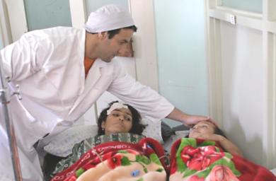 طبيب افغاني يتفقد امرأة وطفلتها اصيبت في الهجوم