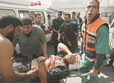 رجال الاسعاف يحملون رجل فلسطيني اصيب في الغارة