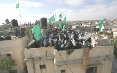 نساء فلسطينيات يقفن فوق سطح احد المنازل لتشكيل درعا بشريا