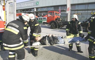 رجال الاطفاء يحملون احد المصابين إلى سيارة الاسعاف