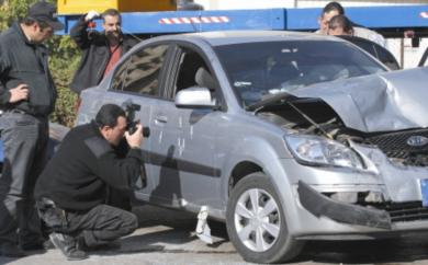 رجل امن يقوم بتصوير آثار الرصاص على باب السيارة التي قتل فيها الجميل 