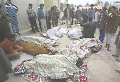 مواطنون عراقيون ينظرون إلى جثث اقاربهم 