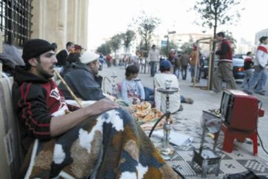 أعضاء من حزب الله يدخنون النارجيلة ويشاهدون التلفزيون أثناء الاعتصام في وسط بيروت أمس
