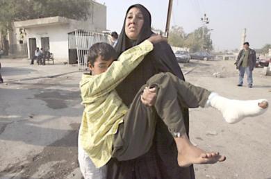 امرأة عراقية تحمل ابنها الذي اصيب في احدى الهجمات