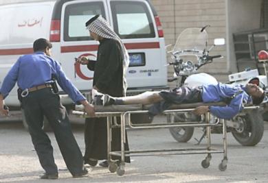 شرطي عراقي يحمل زميلا له اصيب في الهجوم 