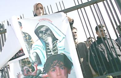 امرأة ليبية تحمل صورة طفل مصاب بمرض نقص المناعة خارج المحكمة