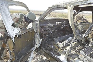 جندي عراقي ينظر إلى حطام السيارة بعد الانفجار الانتحاري