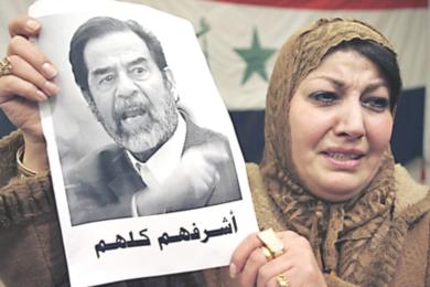 امرأة اردنية تبكي ... وتحمل صورة الرئيس العراقي صدام حسين في المهرجان التأبيني أمس