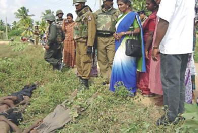 جنود سريلانكيين وسكان محليين ينظرون إلى جثث للمتمردين
