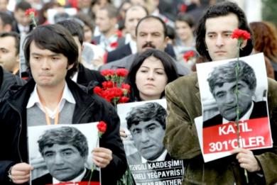 اتراك معارضون يحملون صورا لهرانت دينك خارج مبنى صحيفة «أجوس» الأرمينية في اسطنبول أمس