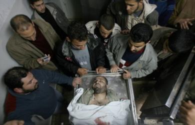 فلسطينيون يلقون نظرة على جثة احد القتلى في المشرحة