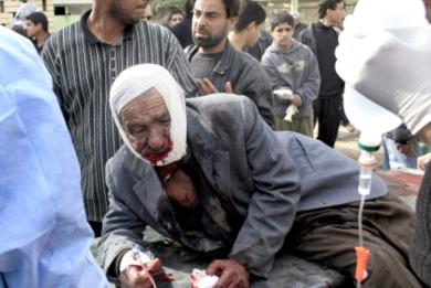 عراقيون ينقلون رجل مسن اصيب بجرح في راسه وفمه إلى المستشفى
