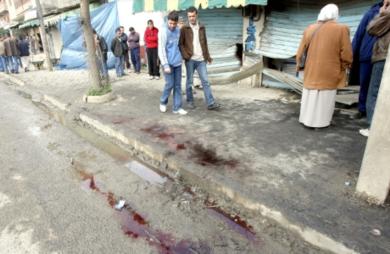 سكان محليين يمشون في الطريق وبقع الدماء تنتشر فيه
