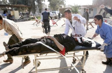 عراقيون ينقلون احد المصابين في حالة خطرة بعد تعرضه لإصابة في الرأس
