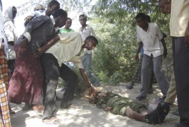 صوماليون يتفحصون جثة احد الجنود
