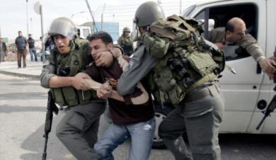 جنديان اسرائيليان يعتقلوا احد المتظاهرين الفلسطينيين
