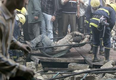عمال الأنقاذ ينتشلون جثة احد القتلى من بين الانقاض
