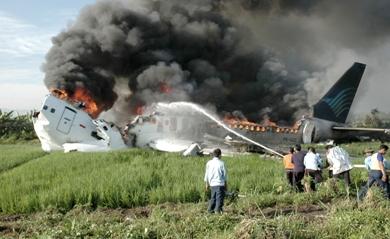 عمال الأطفاء يحاولون اخماد النيران في الطائرة