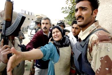 عراقية تتوسل لضباط الشرطة ترك ولدها بينما يقومون هم باعتقاله امس في ضاحية الدرة جنوب بغداد في الصورة على اليسار