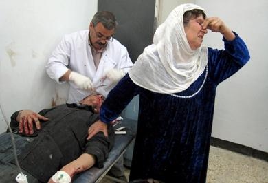 امرأة عراقية تبكي أثناء معالجة ابنها الذي اصيب في احدى الهجمات أمس