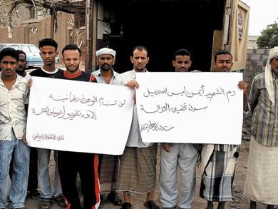 مواطنون يحملون شعارات خارج المحكمة بمدينة الحوطة أمس