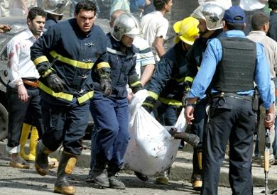 رجال الأطفاء يحملون جثة احد القتلى