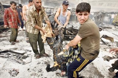 عراقيون ينقلون جثث القتلى المتفحمه