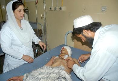 طبيب باكستاني يعلاج احد الجرحى