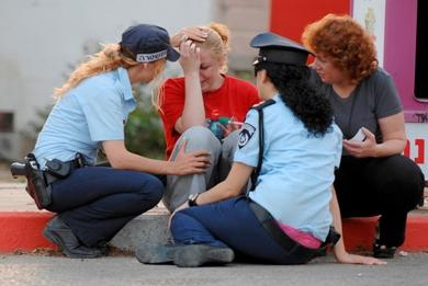 شرطيات اسرائيليات يحاولن تهدئة فتاة اصيبت بالهلع بعد مشاهدتها الانفجار