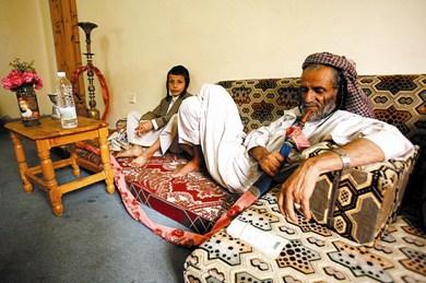 سليمان المرحبي يدخن (المداعة) مع حفيده في منزلهما المؤقت في صنعاء