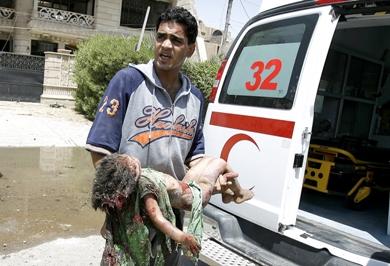 عراقي يحمل جثة طفل قتل في احدى الهجمات أمس