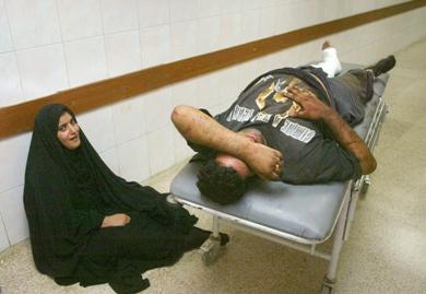 امرأة عراقية تبكي داخل المستشفى وبجانبها قريباً لها مصاب