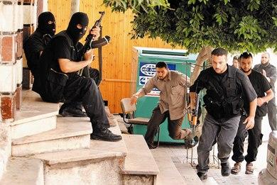 مسلحون فلسطينيون يركضون على إثر اطلاق انار على مكتب رئيس الوزراء الفلسطيني اسماعيل هنية أمس