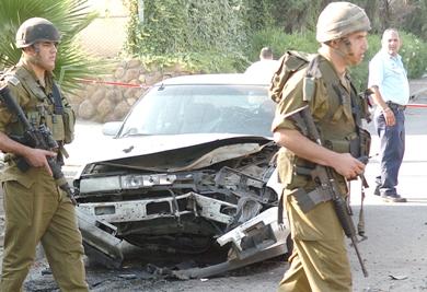 جنود إسرائيليون بمدينة كريات شمونة الحدودية يتفحصون آثار الانفجار الذي خلفه صاروخان كاتيوشا أطلقا من لبنان امس