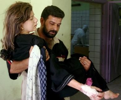 عراقي يقوم بإسعاف شقيقته بعد اصابتها في احد الانفجارات