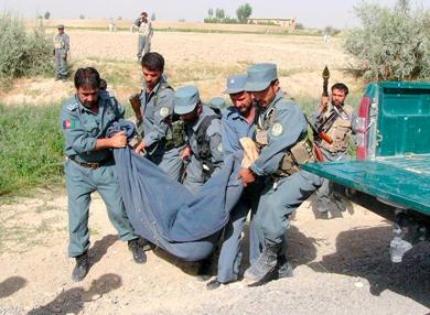 عناصر من الشرطة الافغانية يحملون جثة الرهينة