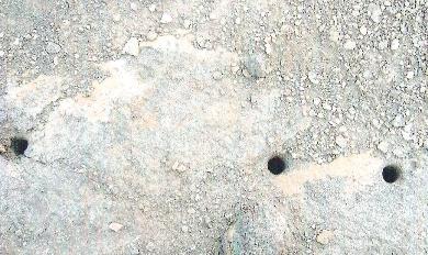 المواد المتفجرة مرمية في الطريق كما تبدو الحفر التي توجد بها الصواعق