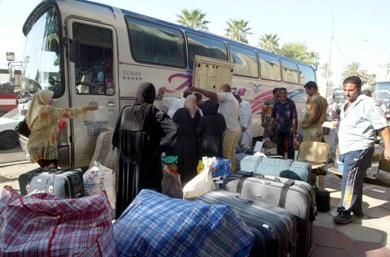 عراقيون يحملون امتعتهم الى حافلة متجهة الى سوريا يوم أمس الى سوريا