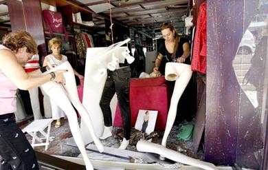 نساء لبنانيات ينظفن المحل بعض أن تضرر بسبب الانفجار