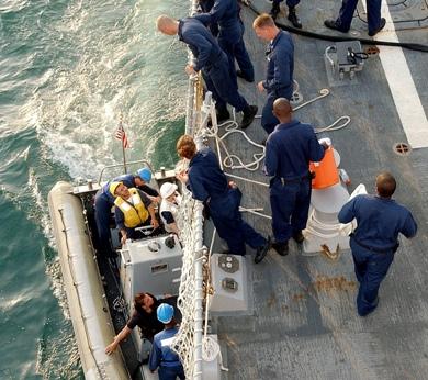 المدمرة الأميركية أثناء تزويدها لنشات البحث والإنقاذ بالوقود بعرض البحر