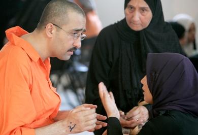 معتقل عراقي يستمع الى زوجته خلال زيارته الشهرية بسجن بغداد